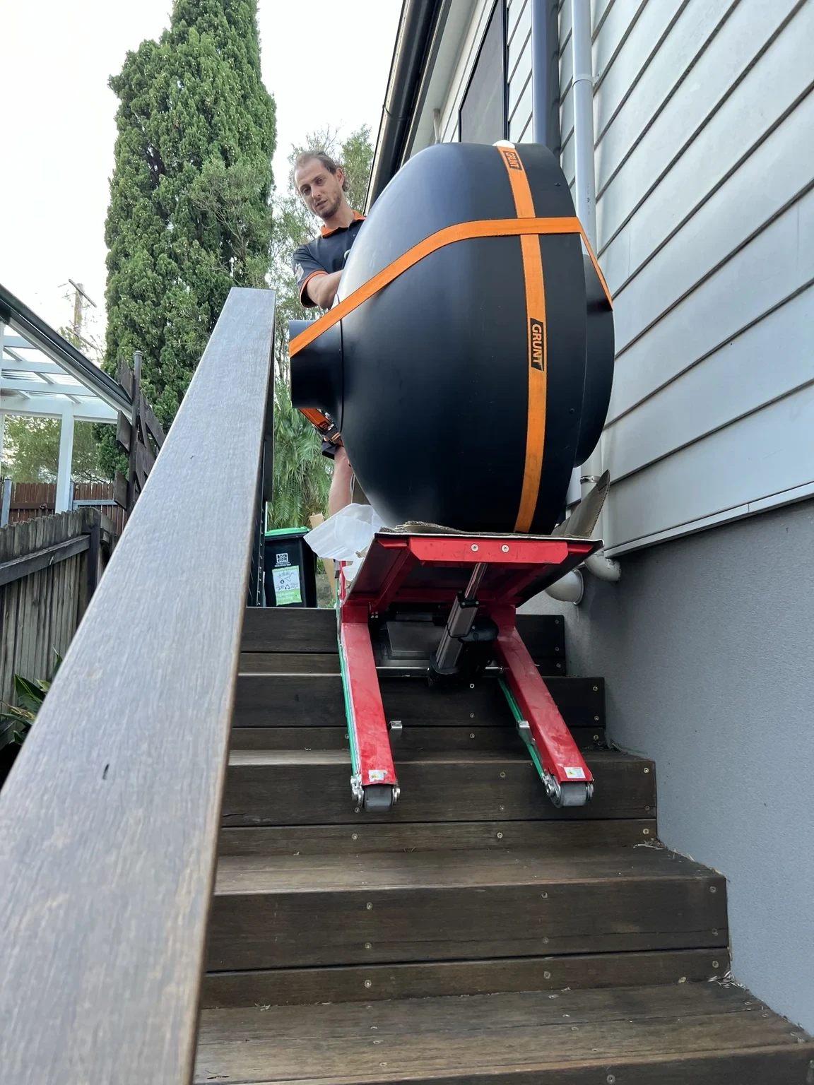 250 kg pizza oven strapped to a stair climber between a handrail and house wall